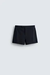 Shorts de corte sastrero confeccionados en tejido de piqué elástico, con cierre frontal de cremallera y gancho metálico oculto, y bolsillos laterales.