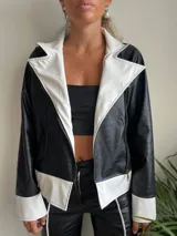 Campera de cuero sintético negra con textura de cocodrilo, con cuello, solapas y puños en color blanco.