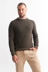 Sweater marrón de punto melange con cuello redondo y mangas largas.