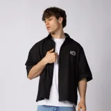 Camisa de manga corta negra con fit boxy, confeccionada en algodón con bordado frontal pequeño con las iniciales VCP.