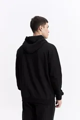 Canguro oversize de algodón, color negro, con capucha ajustable, bolsillo frontal tipo canguro y estampa sutil en el pecho.