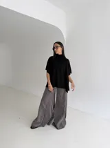 Poncho de tejido de punto color marrón chocolate, con cuello alto tipo polera y mangas cortas amplias. Presenta un diseño holgado con terminaciones acanaladas en el ruedo.