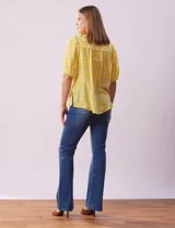 Blusa amarilla estampada con cuello en V, manga corta con volados y ruedo anudado.