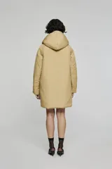 Campera reversible de corte regular, confeccionada en nylon con acabado repelente al agua. Presenta diseño con capucha, mangas raglán y cierre frontal con botones. Un lado es de color negro con bolsillos de parche, mientras que el reverso es de color plateado con bolsillos laterales integrados.