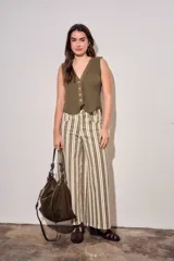 Jean wide leg de tiro alto con diseño de rayas verticales en tonos verde militar, borravino y crudo. Cuenta con bolsillos delanteros y traseros, y cierre frontal con botón y cremallera.