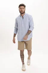 Camisa celeste de lino, de corte clásico, manga larga y cuello abotonado.