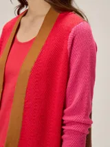 Saco abierto de tejido de punto con diseño de bloques de color. Presenta cuerpo en rojo con solapas en tono tostado y mangas largas en color fucsia con textura acanalada.