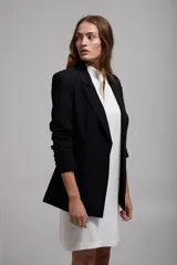 Blazer negro de corte clásico, con solapas de muesca y cierre frontal con un botón.