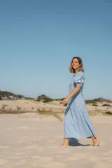 Vestido midi celeste de corte recto, con mangas cortas abullonadas con detalle de bordado floral en los hombros.