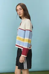 Cardigan de punto con diseño de rayas horizontales en colores celeste, amarillo, bordó y natural, escote redondo y cierre frontal de botones.