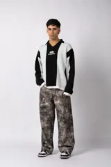 Sweater de punto con diseño a rayas verticales en color beige y blanco, de corte holgado y cuello polo abierto. Presenta un logo bordado en el centro del pecho.