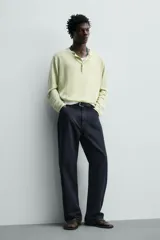Pantalón cargo straight fit de algodón color negro con efecto lavado, bolsillos laterales en las piernas y cierre frontal con cremallera y botón.