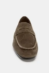 Mocasín de mujer confeccionado en serraje, con diseño de antifaz en el empeine y punta redonda. Presenta una suela plana de 2 cm.