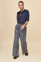 Pantalón gris de corte amplio y silueta fluida, con cintura elástica y cordón ajustable.