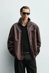 Sobrecamisa relaxed fit de cuero color marrón oscuro, con cuello solapa, manga larga con puño abotonado, bolsillo de parche en el pecho y cierre frontal de botonadura.