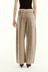 Pantalón de tiro medio en color marrón con diseño de animal print y aplicaciones de brillos en contraste. Cuenta con cinco bolsillos, presillas para cinturón y cierre frontal con cremallera y botón metálico.
