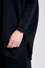 Buzo de punto de corte oversize en color negro, con cuello redondo y mangas largas con puños ajustados.