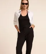 Pantalón de vestir femenino color marrón oscuro, de corte fluido y tiro medio/alto, con cintura elástica ajustable mediante cordón. Presenta bolsillos laterales y cierre frontal.
