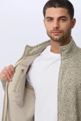 Campera texturada con interior en polar, color tostado jaspeado, cuello alto y cierre frontal con cremallera.