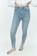 Jeans skinny de tiro alto y largo al tobillo, confeccionados en tejido super elástico con diseño de cinco bolsillos, cierre frontal con cremallera y botón metálico.