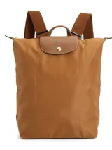 Mochila Longchamp modelo Le Pliage Original en tamaño M, color verde oscuro. Presenta solapa y asas de cuero marrón con cierre de botón a presión, correas ajustables de tela y cierre superior con cremallera.