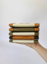 Billetera triple de cuero color verde oliva, marrón y negro, con cierre de broche y monedero externo.