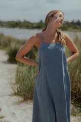 Vestido midi de denim color celeste, con escote recto, breteles finos y corte evasé amplio.
