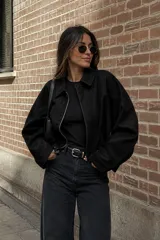 Campera de gamuza negra con cierre frontal, cuello clásico y diseño de corte holgado con hombros caídos.