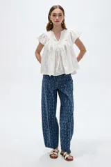 Blusa de algodón blanca con cuello en V, frunces frontales y mangas cortas con volados.