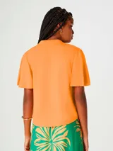 Blusa color naranja con escote en V y botones frontales. Manga corta.