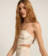 Vestido midi de bengalina con estampado manchado, escote recto sin breteles, detalle de recortes laterales, lastex en la espalda, cremallera y encaje.