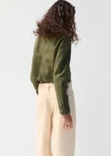 Chaqueta estilo militar color verde militar, confeccionada en algodón, con cuello alto, cierre frontal de cremallera y doble botonadura metálica decorativa.