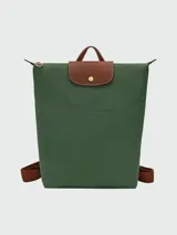 Mochila Longchamp modelo Le Pliage Original en tamaño M, color rosado con solapa y detalles en cuero marrón. Cuenta con correas ajustables de tela y cierre superior con solapa de botón a presión.