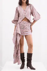 Minifalda semi entallada de tafeta rosada con rayas verticales oscuras, diseño drapeado y un lazo largo lateral.