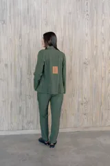 Pantalón de vestir color crema con raya diplomática vertical, corte recto y tiro medio.