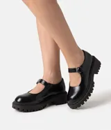 Zapato Mary Jane Satinato negro de poliuretano, con diseño cerrado de puntera redondeada, tira con hebilla ajustable y suela tractorada de altura media.