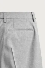 Pantalón de traje slim fit color gris, con bolsillos frontales, bolsillos traseros de doble vivo, trabillas para cinturón y cierre frontal con cremallera y botón.
