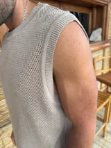 Musculosa color beige de punto calado, con cuello redondo y sisas amplias.