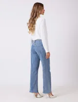 Jean recto de mujer, color azul claro, con pretina con pasadores, botón y cierre. Cuenta con bolsillos delanteros y traseros, y costura lateral asimétrica.