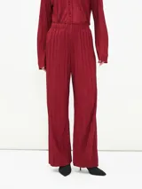 Pantalón de vestir color borgoña, de corte palazzo y tela plisada.