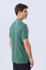 Remera polo de piqué azul marino, con cuello y puños de mangas cortas con ribete blanco en contraste, cierre frontal de dos botones y pequeño logo bordado en el pecho.