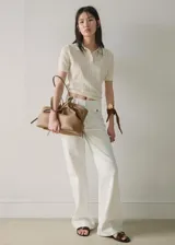 Pantalón wide leg de tiro medio confeccionado en denim de algodón, de color blanco, con trabillas para cinto y bolsillos de solapa delanteros.