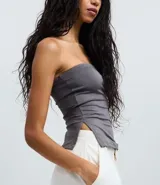 Blusa blanca sin breteles, confeccionada en microfibra, con detalle de encaje en el lateral y corte ajustado.