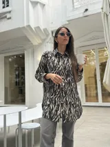 Camisa con estampado de cebra, de corte amplio y fluido, con cuello camisero y cierre frontal con botones.