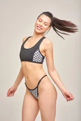 Top deportivo con espalda nadadora, tirantes anchos y fijos, de color negro con detalles laterales estampados en tonos celestes, amarillos y fucsias.
