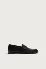Mocasín de vestir negro confeccionado en piel, con detalle fruncido en la parte delantera y antifaz en el empeine. Cuenta con suela a tono y ligero tacón.