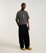 Remera gris de corte boxy, confeccionada en tejido de punto con efecto desteñido. Presenta cuello redondo, mangas cortas y estampado de Pinky y Cerebro en la espalda.