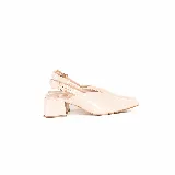 Zapato de tacón medio y punta fina en charol color off-white, con diseño destalonado y tira ajustable con hebilla dorada en el talón.