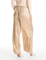 Pantalón de corte wide leg en tejido laminado metalizado color gris. Presenta pretina ancha elastizada con lazo de ajuste y bolsillos delanteros.