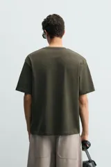 Remera de corte relaxed fit confeccionada en tejido de algodón con textura irregular, cuello redondo y manga corta.